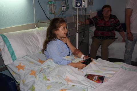 Una niña hospitalizada juega a la videoconsola donada por Juegaterapia